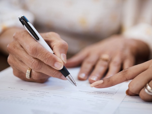 shot-of-a-woman-going-over-paperwork-with-her-elderly-mother-at-home 600 x 450